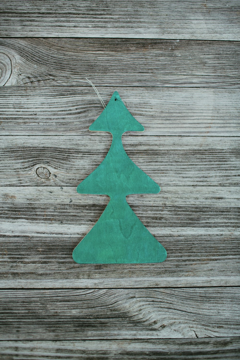 green pine tree car freshener on wooden surface