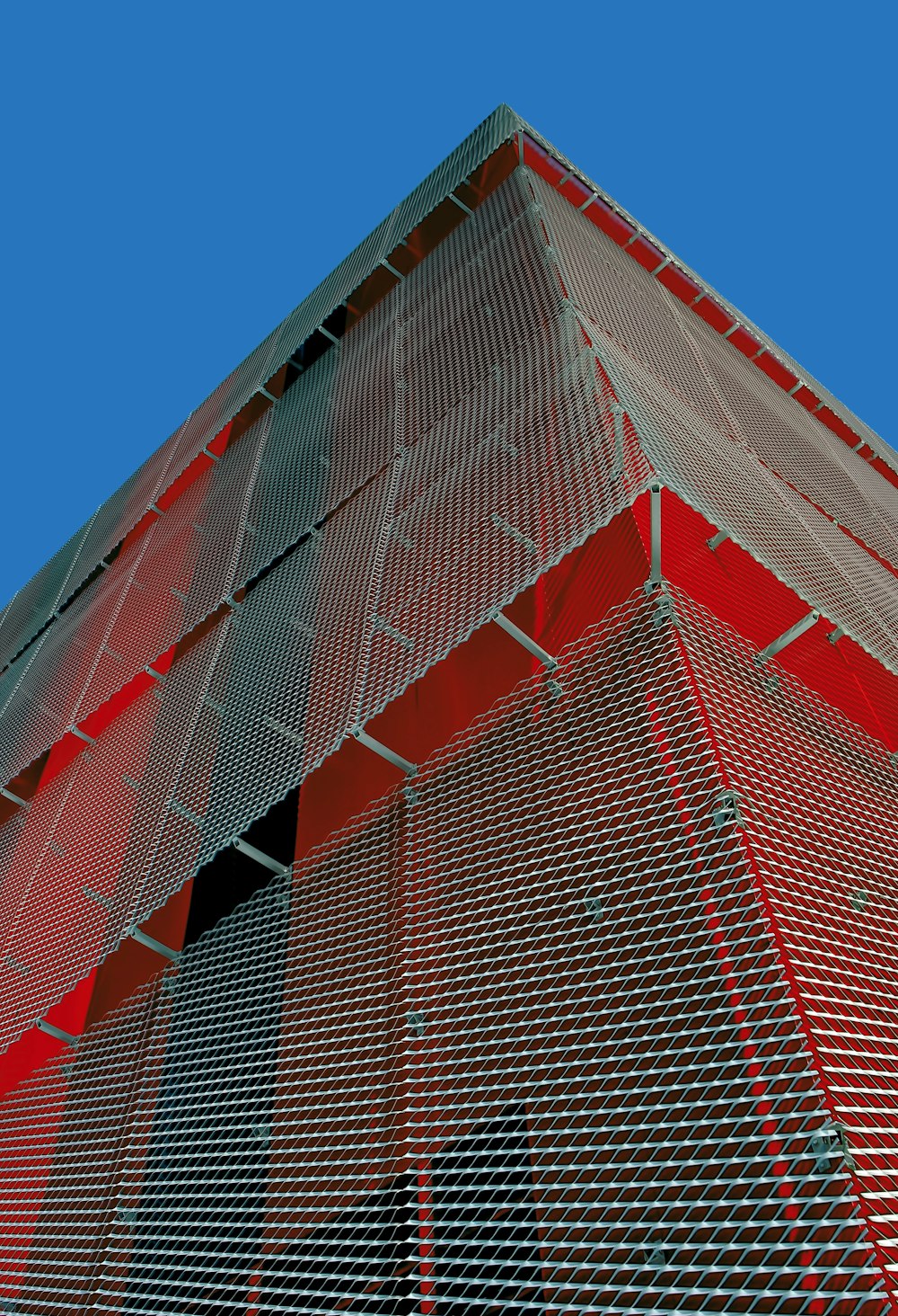 red and gray high-rise building under blue sky