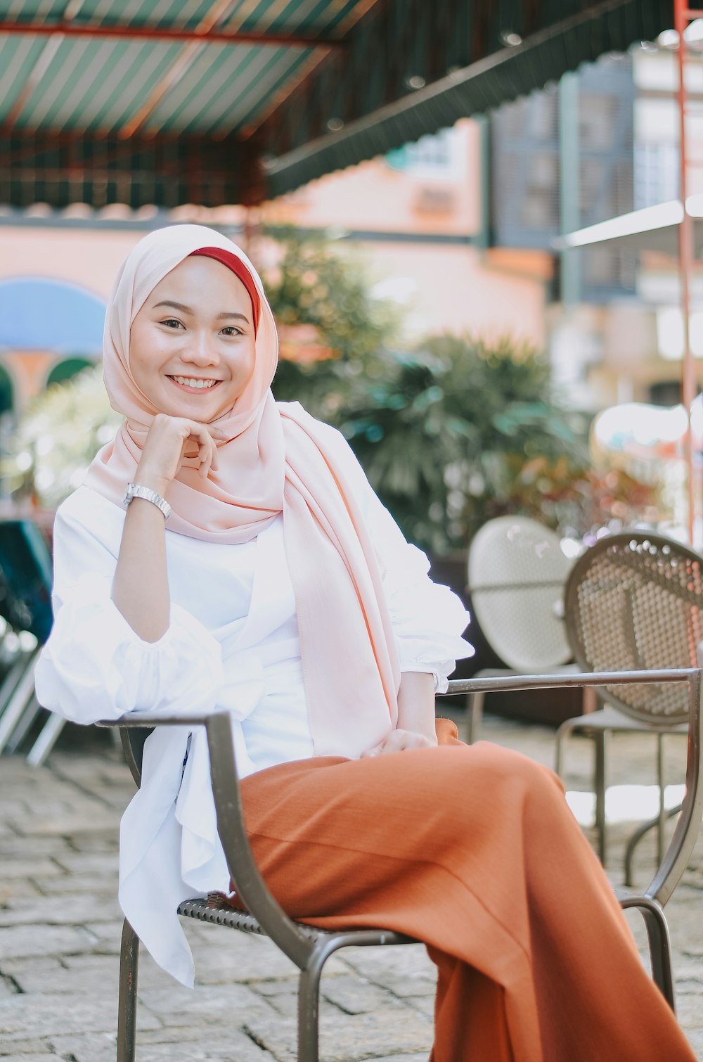 a woman wearing a hijab sitting on a chair