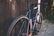 A close-up of a well-maintained road bike leaning against a rustic wooden fence.
