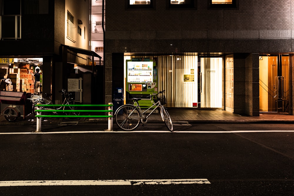 black bike parking near road and raising during night time