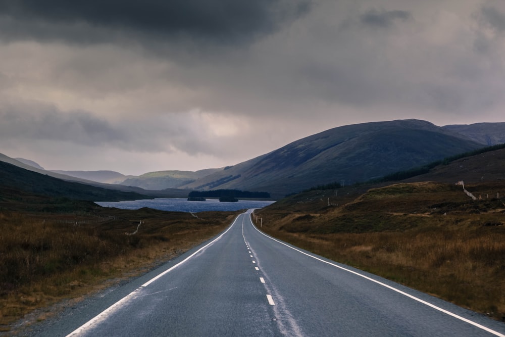 gray asphalt road under nimbus clouds