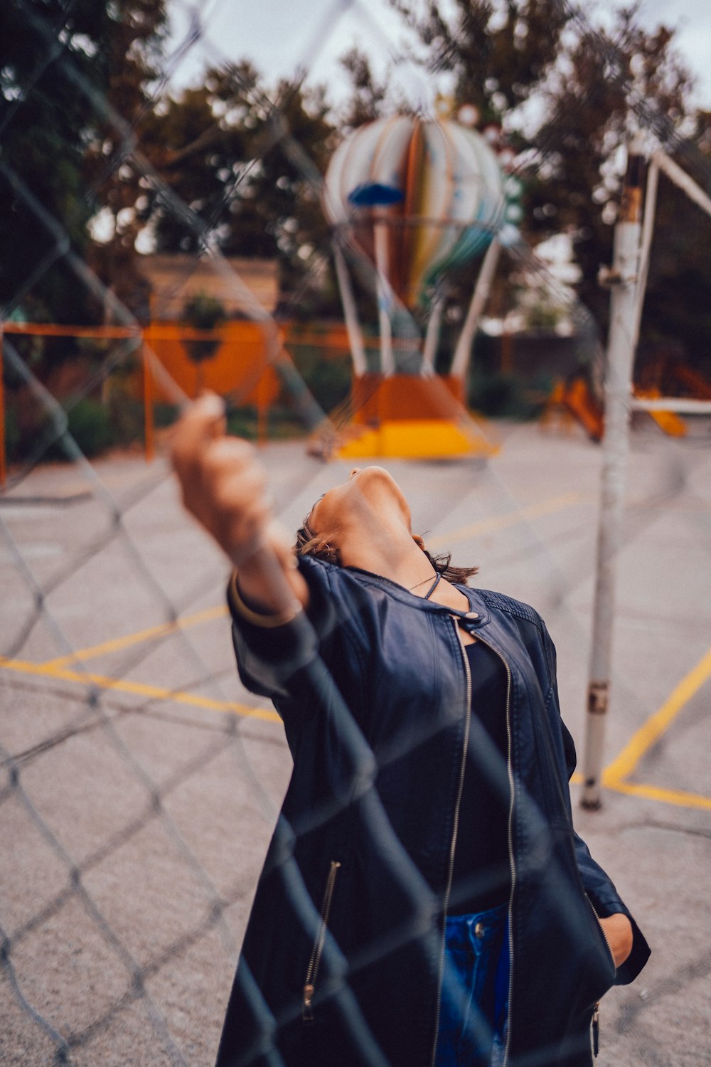 woman holding chainlink fence