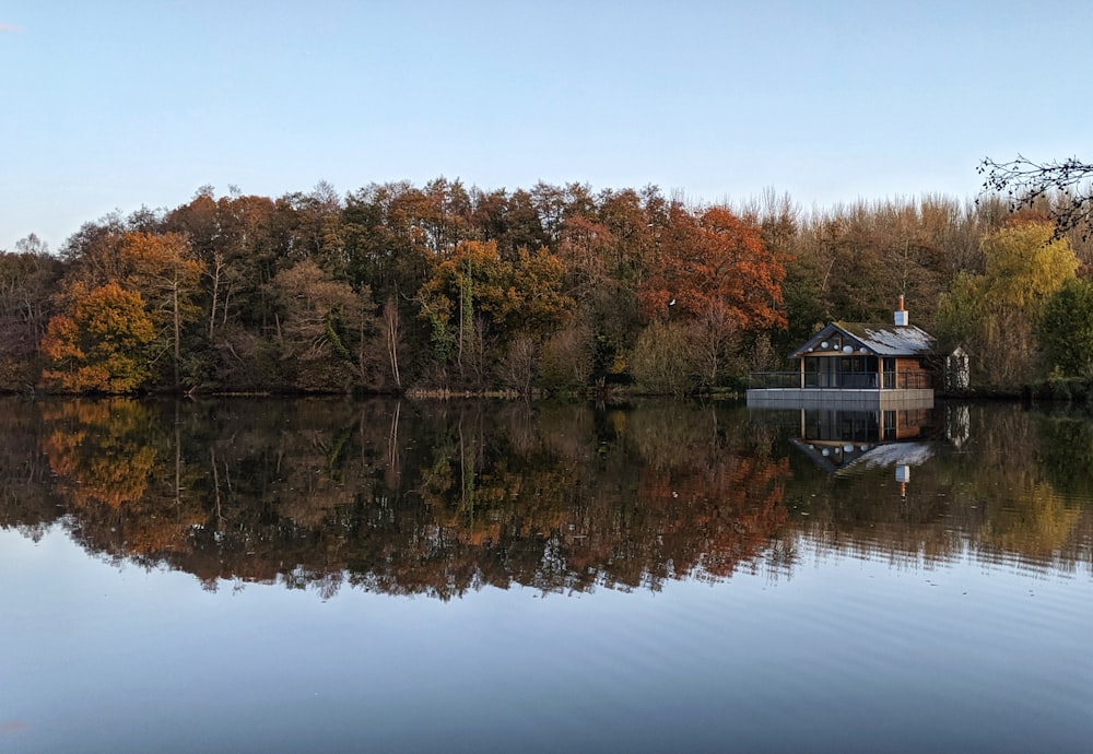 나무로 둘러싸인 호수 위의 집