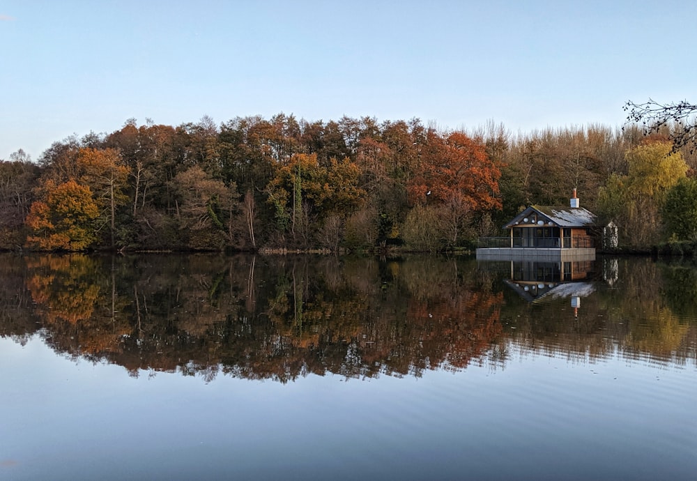 a house on a lake surrounded by trees