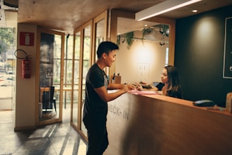 man in black shirt standing beside counter