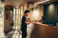 man in black shirt standing beside counter