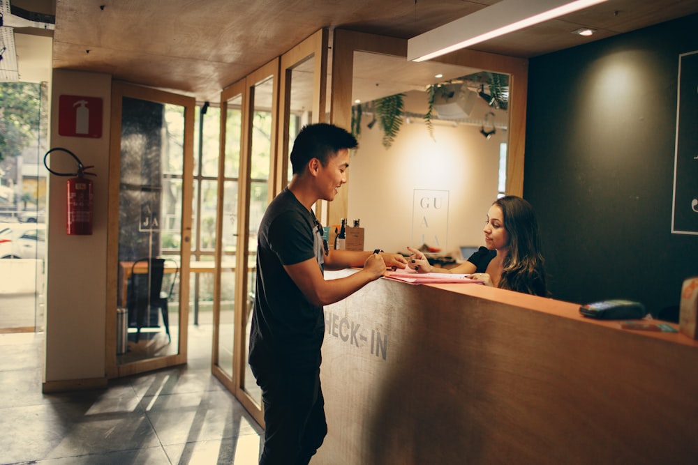 man in black shirt standing beside counter