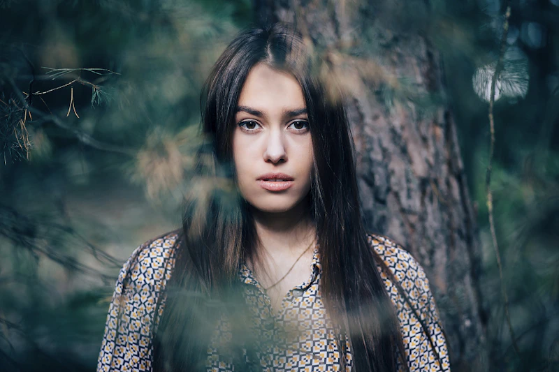 Woman standing beside a tree