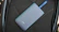 A sleek power bank glowing softly in electric blue light on a dark matte surface.