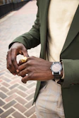 Street-style shot of a young woman adjusting her sleek watch and rings while walking downtown.