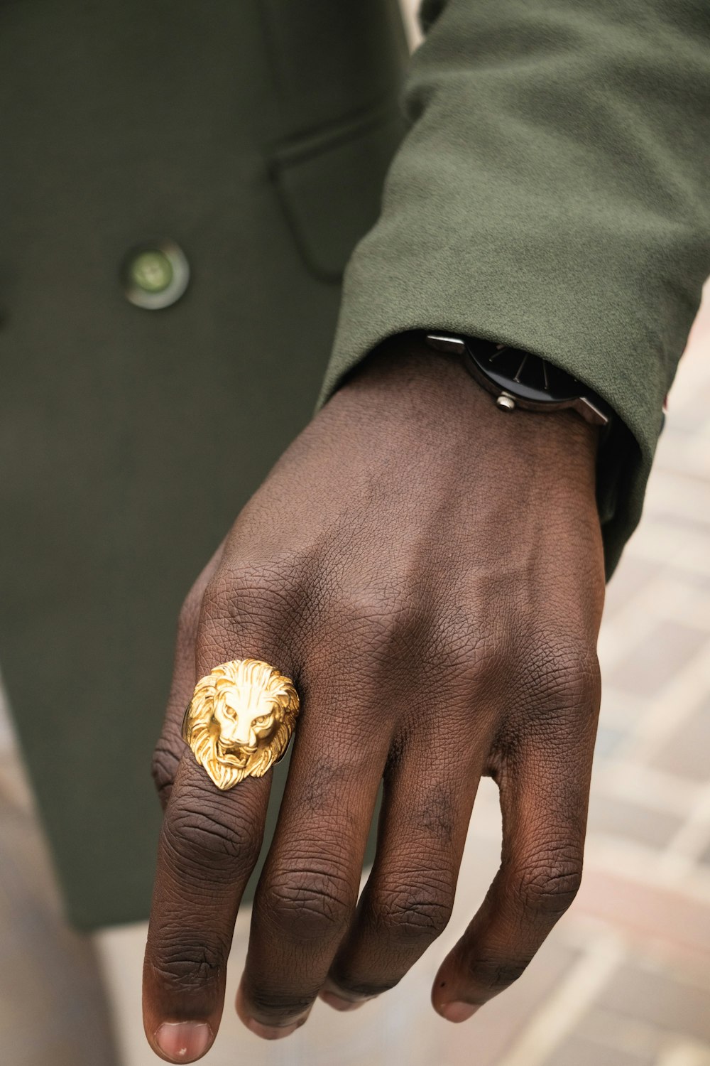 man wearing gold-colored lion ring