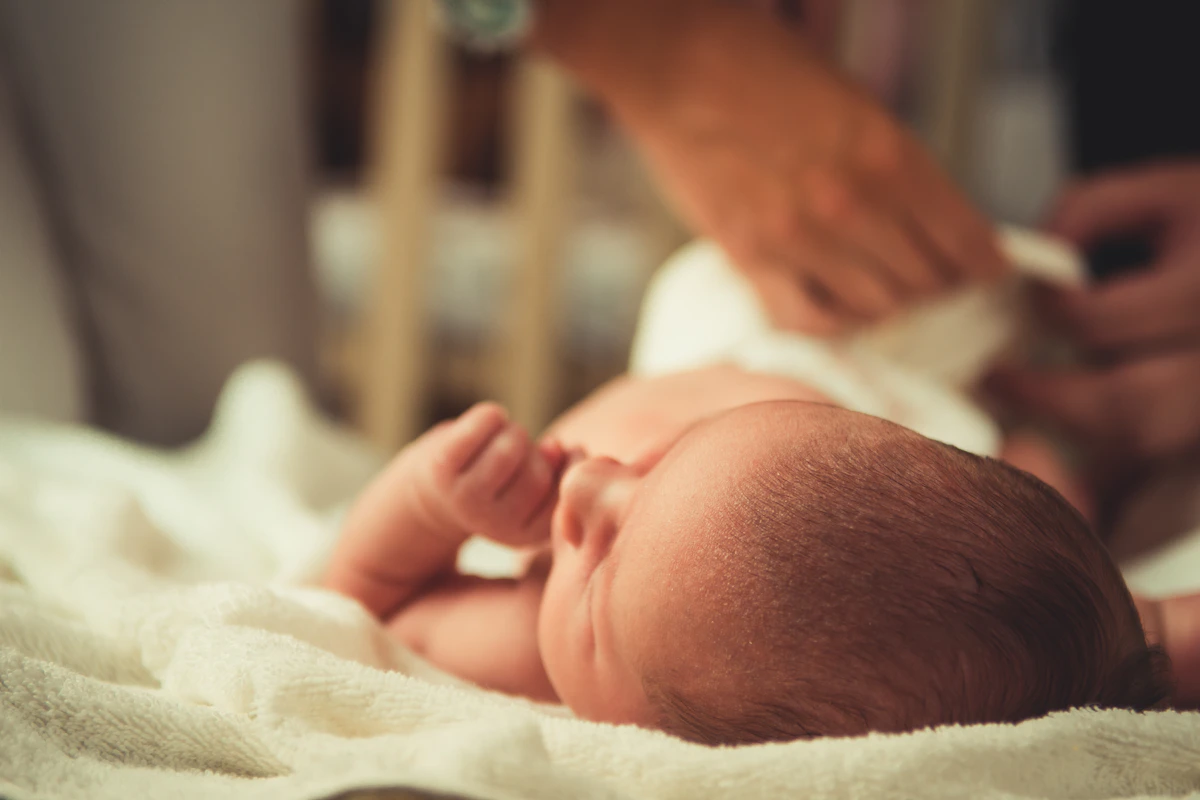 Bayi berbaring nyaman saat orang tua menyentuh dengan lembut