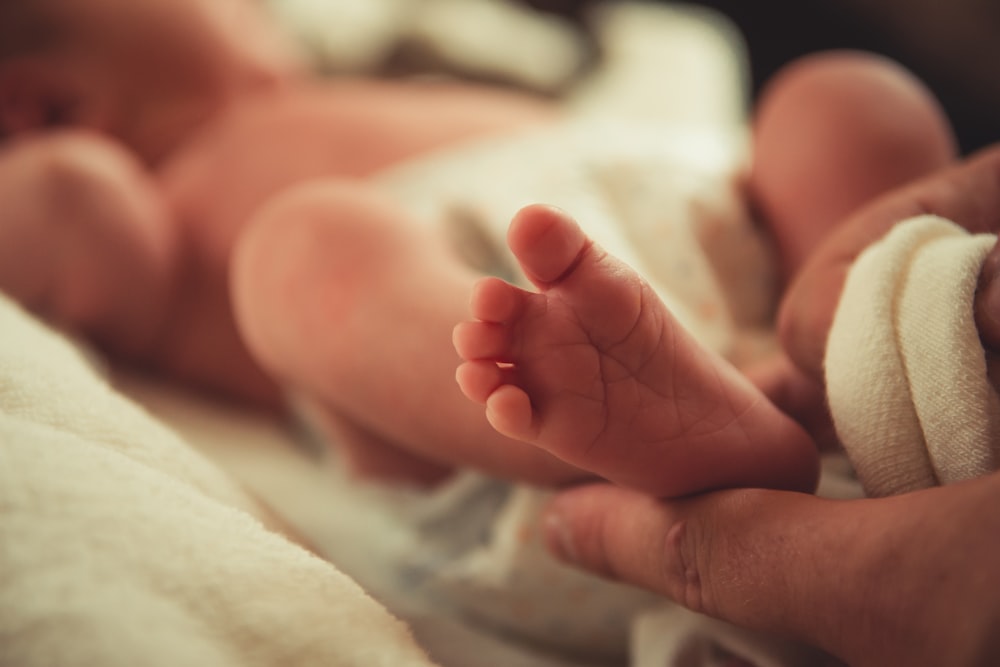 fotografia de foco seletivo do pé do bebê