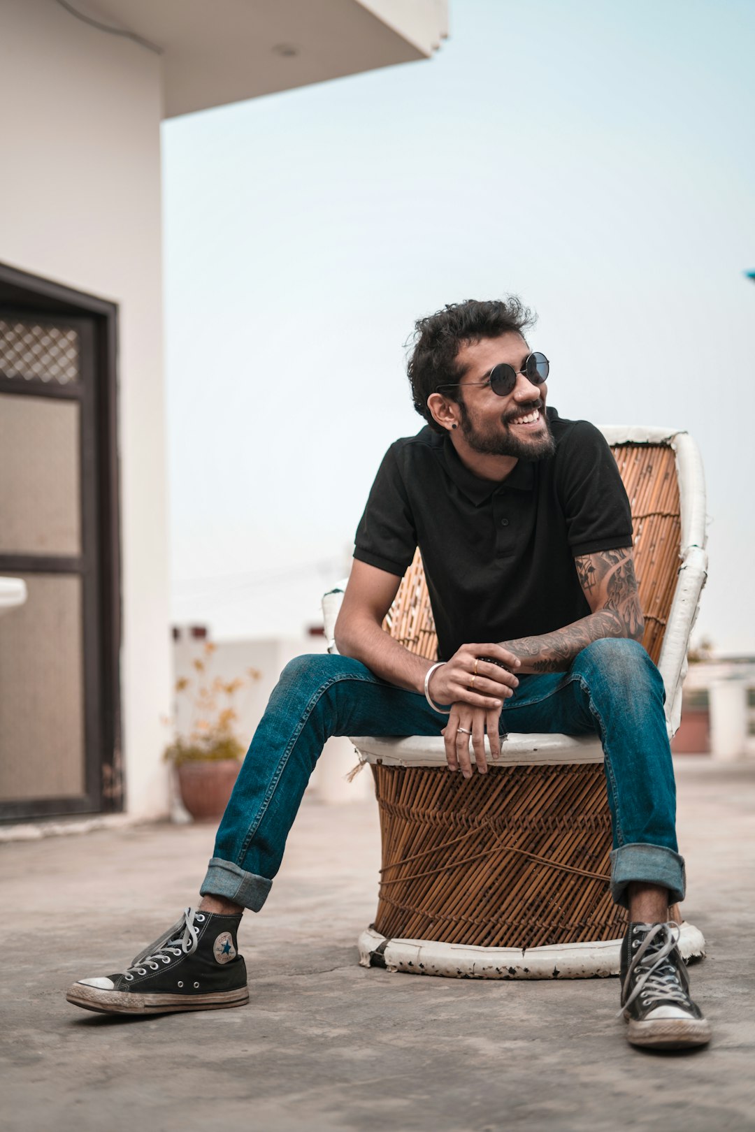 man sitting on brown wicker chair