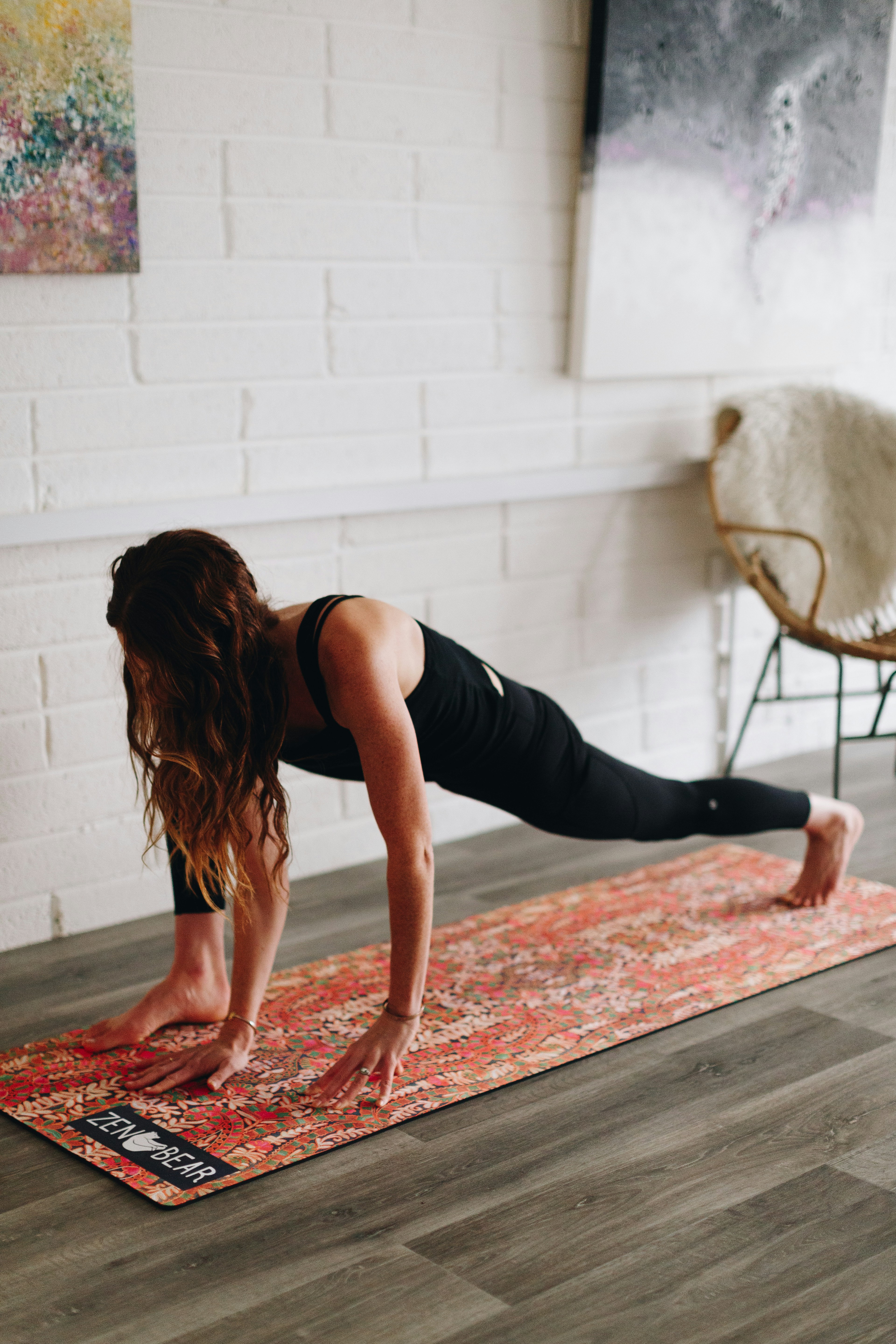 woman bend down on orange floral mat inside room