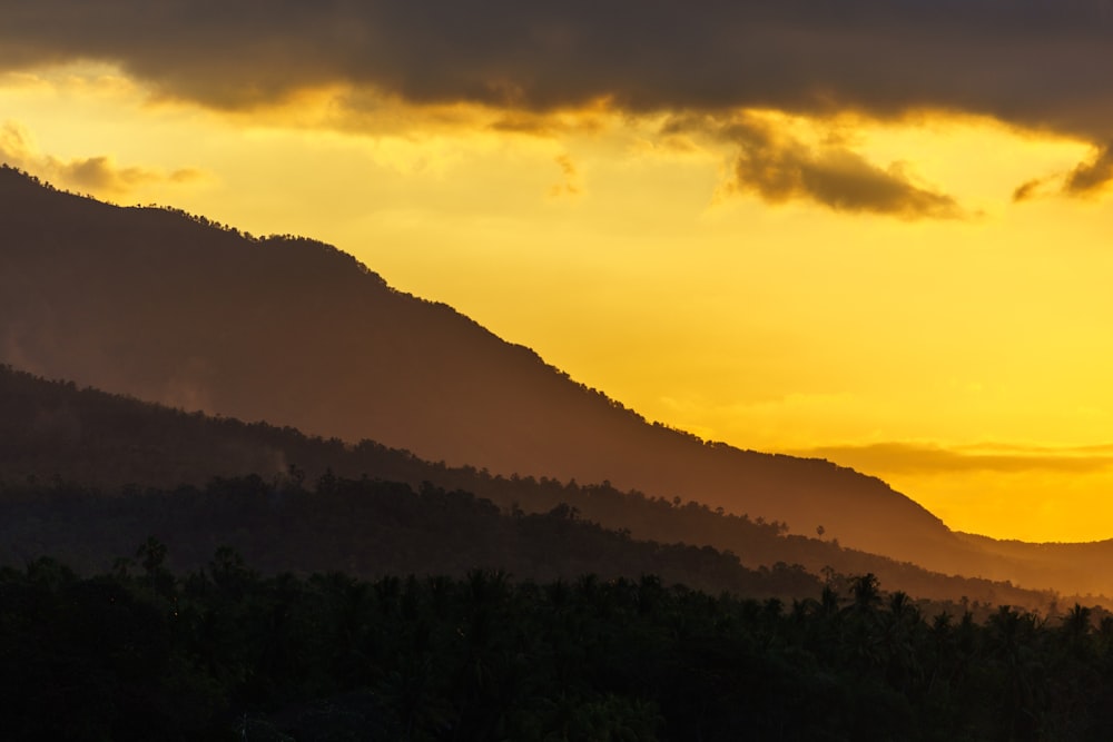 the sun is setting behind a mountain range