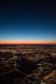 A sweeping drone shot of Manchester's skyline at dusk, with glowing city lights.