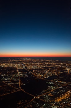 Modern city grid with street electrical lines and glowing office buildings at dusk.