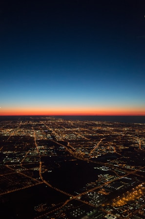 A cinematic video still of a cityscape at dusk with glowing lights.