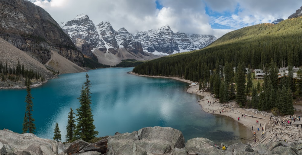 calm body of water overlooking snow capped mountains