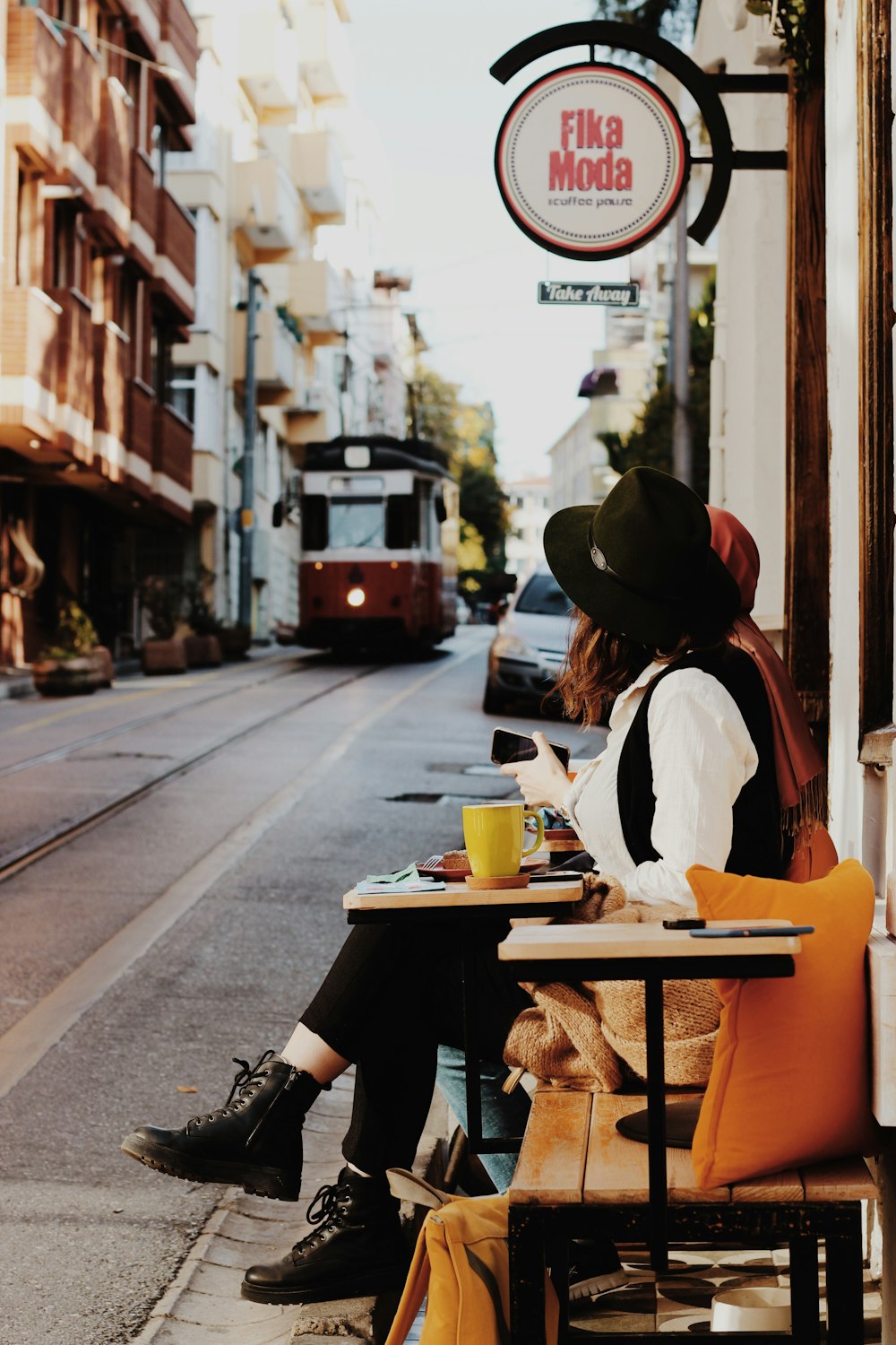 Frau sitzt tagsüber auf einer Bank neben der Straße
