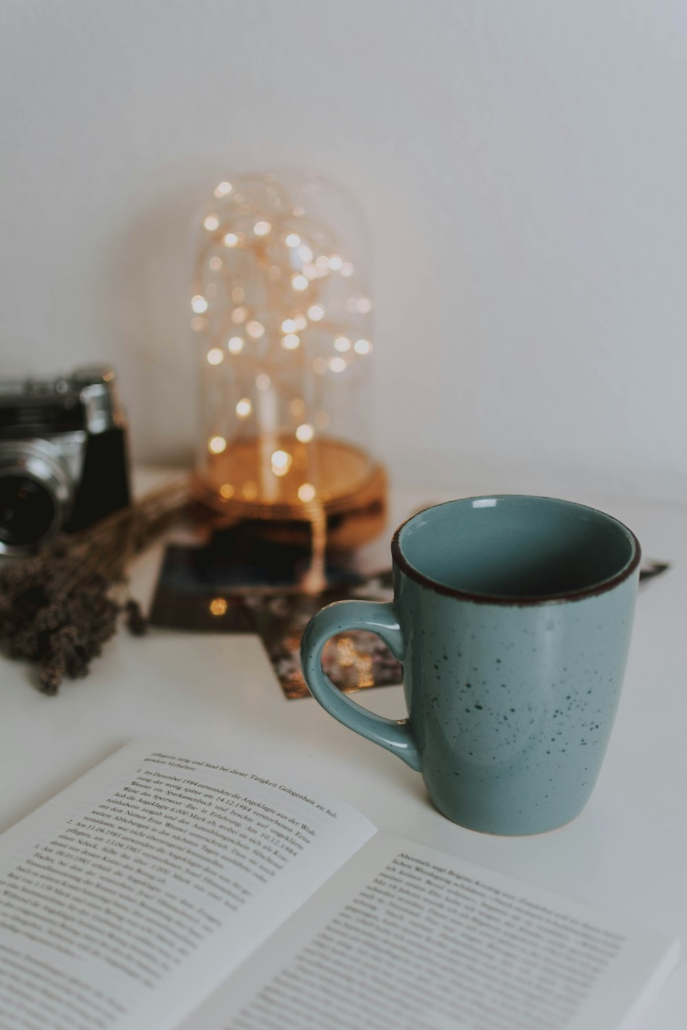 blue ceramic mug near book