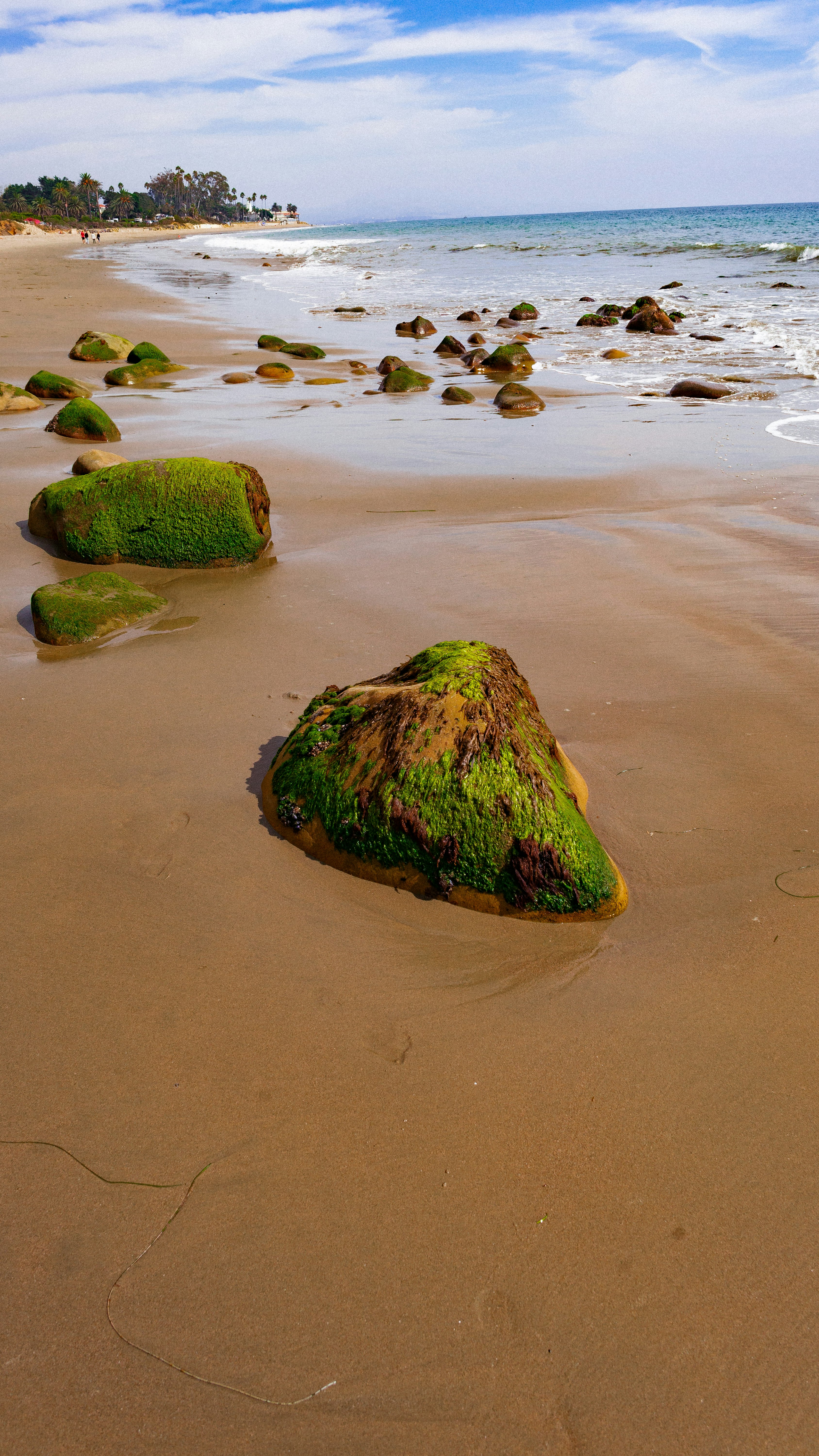 brown rocks near seashore under white and blue sky