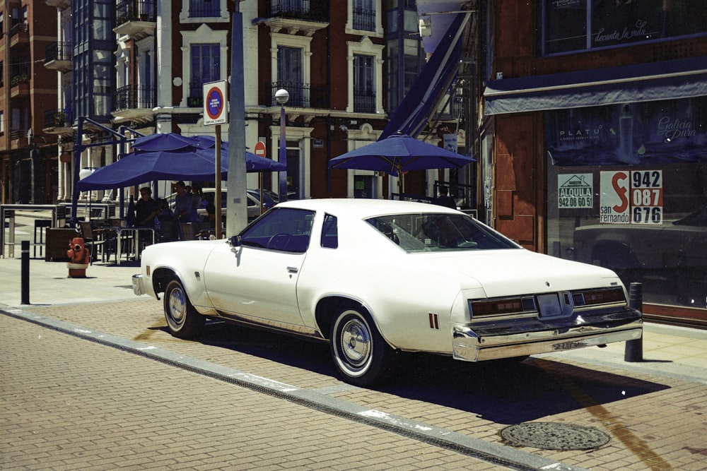 parked vintage white coupe during daytime