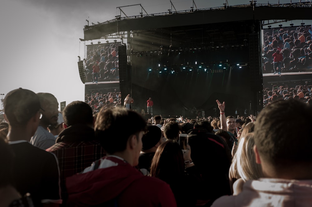 crowd in front of black stage during daytime