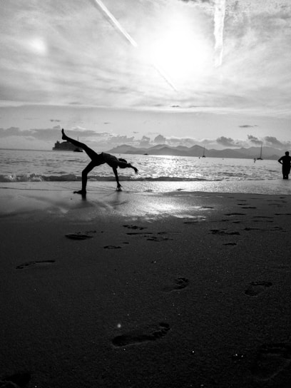 A sunlit morning yoga session on a serene beach, with waves gently rolling in the background.