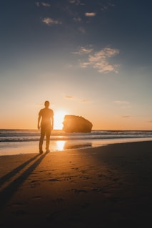 person standing at the beach during golden hour