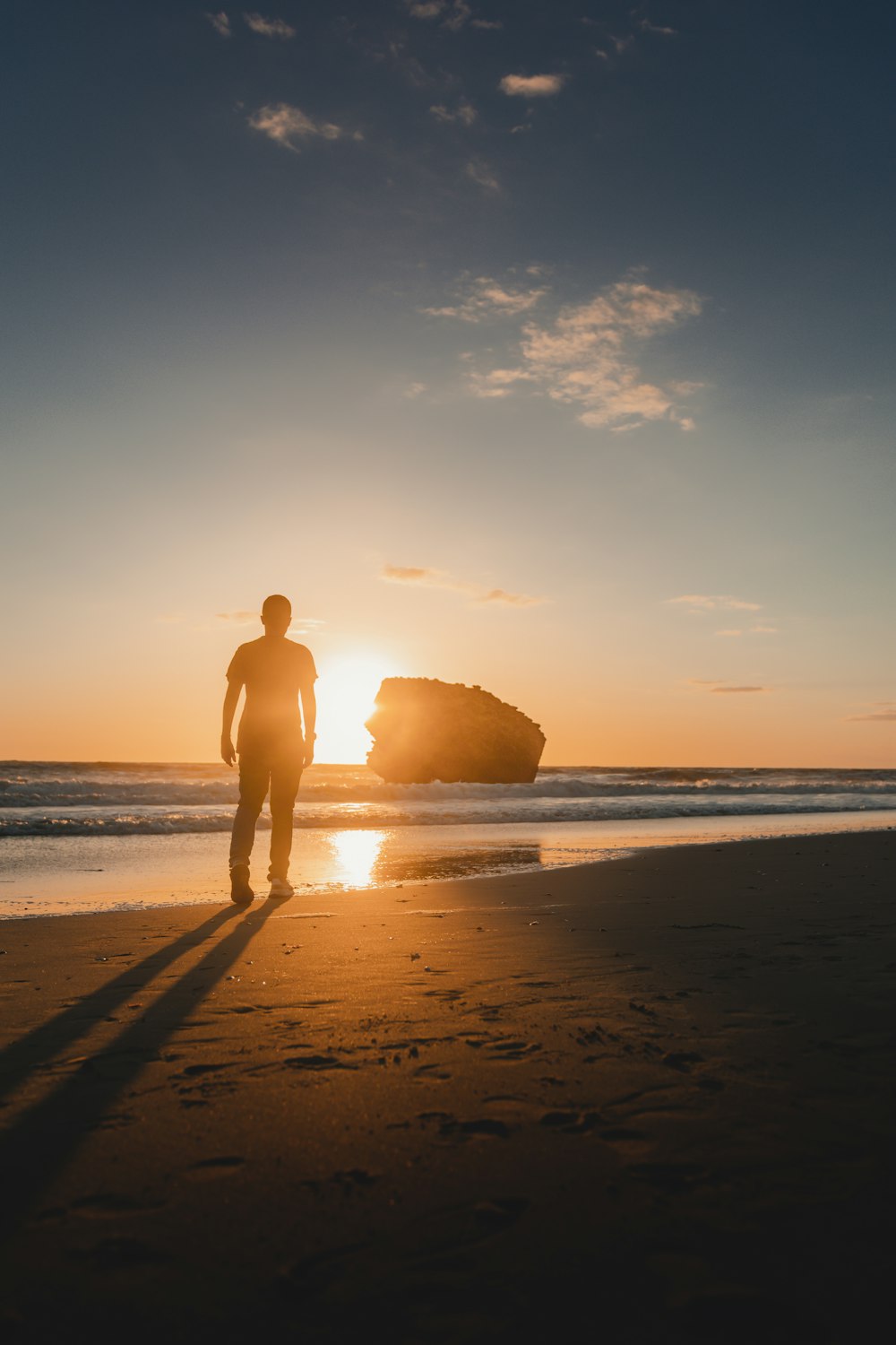 person standing at the beach during golden hour