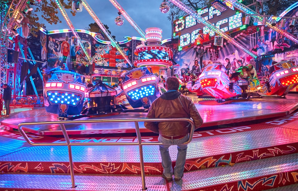 man standing beside amusement ride