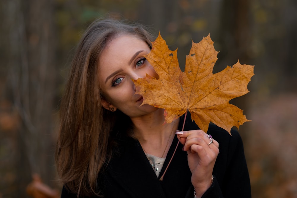 woman holding fallen brown leaf