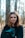 woman in black jacket beside tree