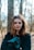 woman in black jacket beside tree