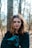 woman in black jacket beside tree