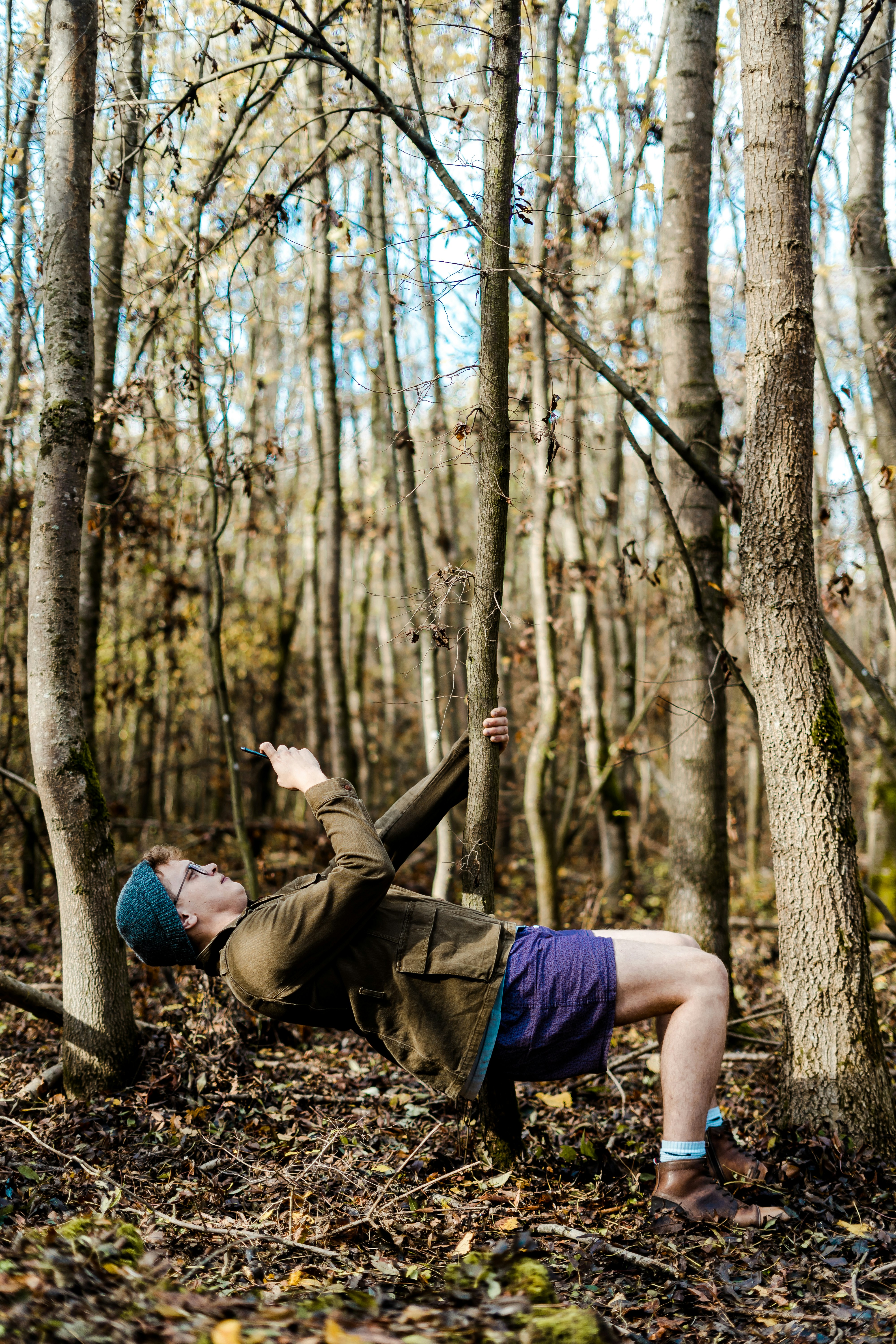 man holding onto tree while lying down