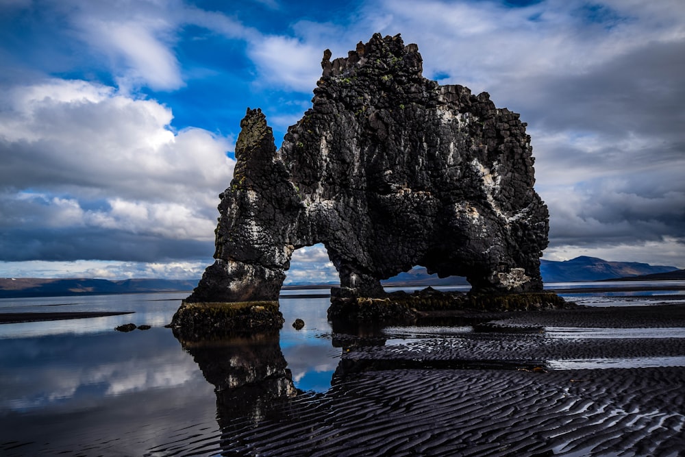 black rocky mountain on shore during day