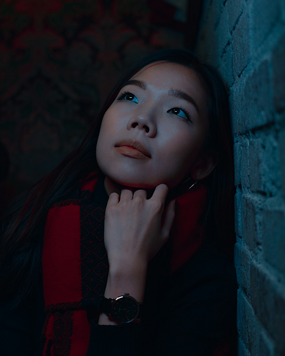 woman in red and black shirt by concrete wall