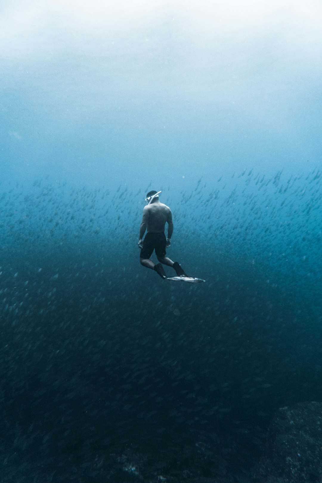 man swimming on the body of water