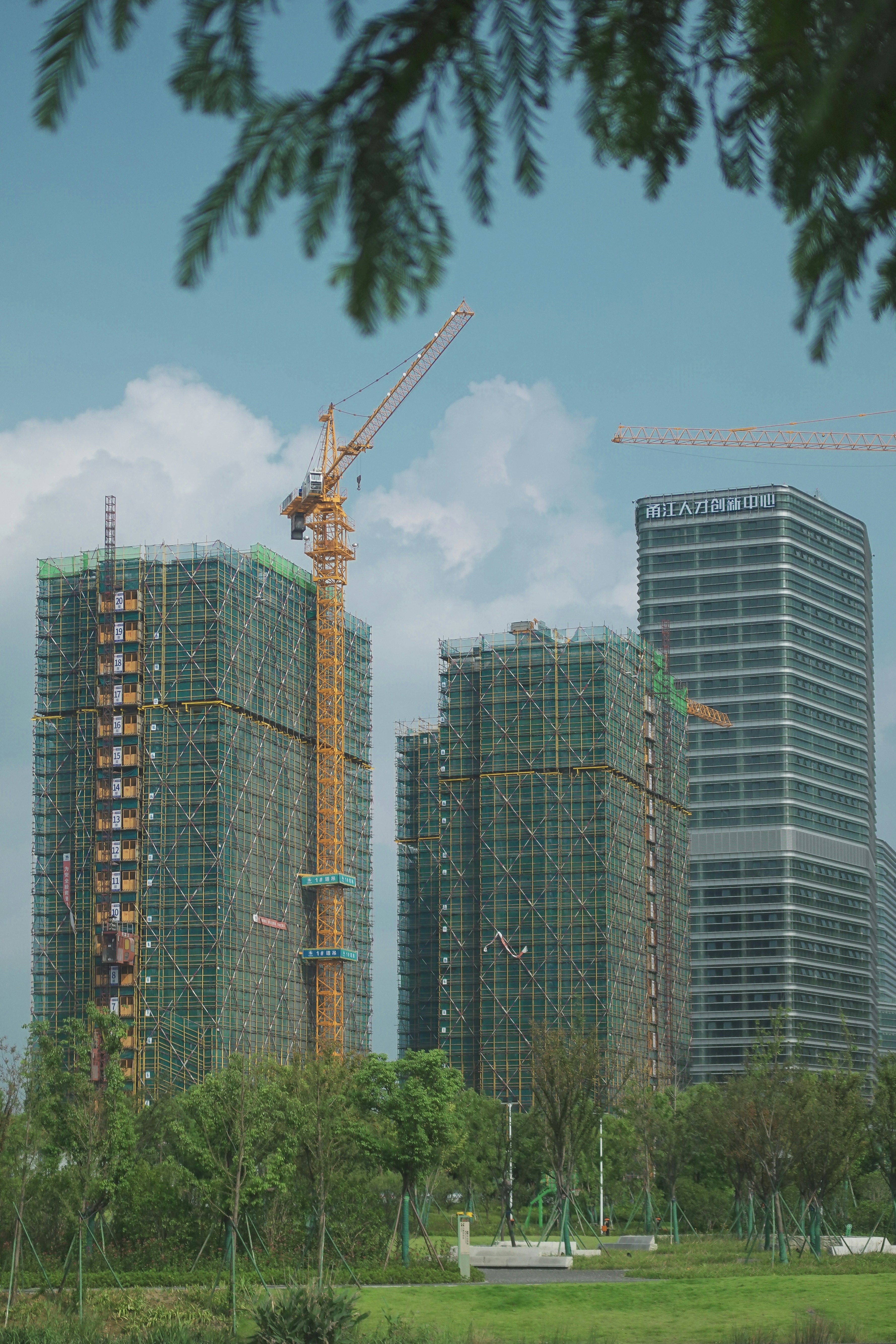 yellow crane near buildings during daytim