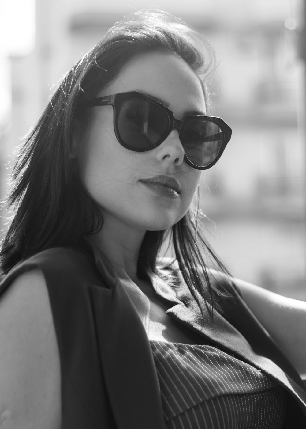 grayscale photography of woman wearing sleeveless blouse and sunglasses