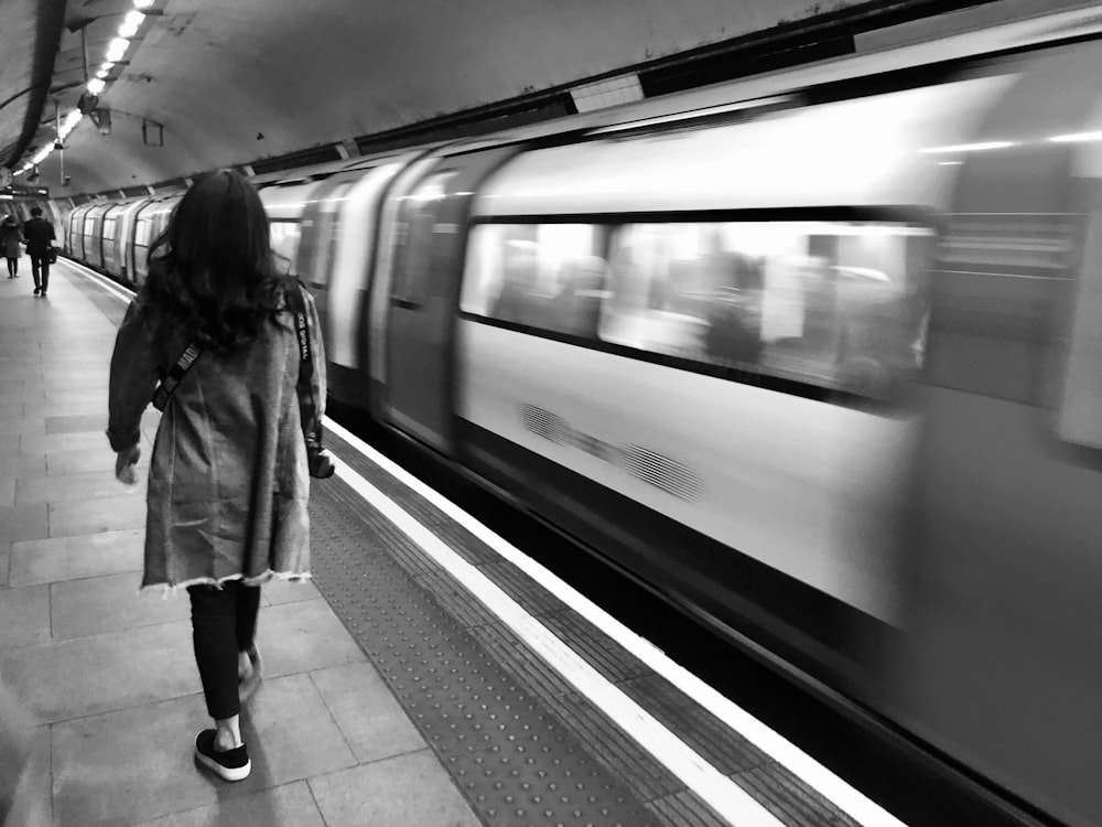 donna che cammina alla stazione ferroviaria