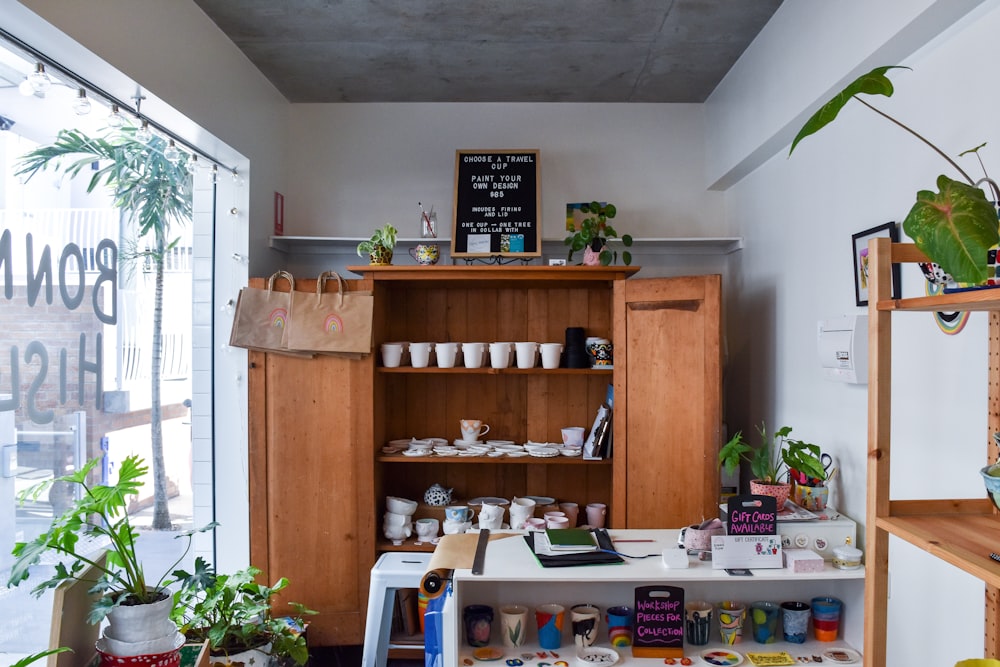 rectangular white wooden table near brown wooden cabinet with ceramic tea set