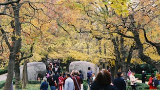 Tourists enjoying a sunny stroll through Vigeland Sculpture Park surrounded by unique statues.