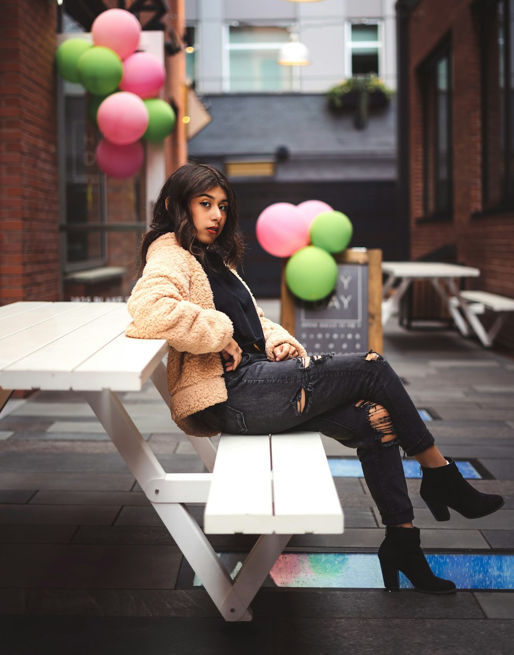 woman sitting on picnic table during day