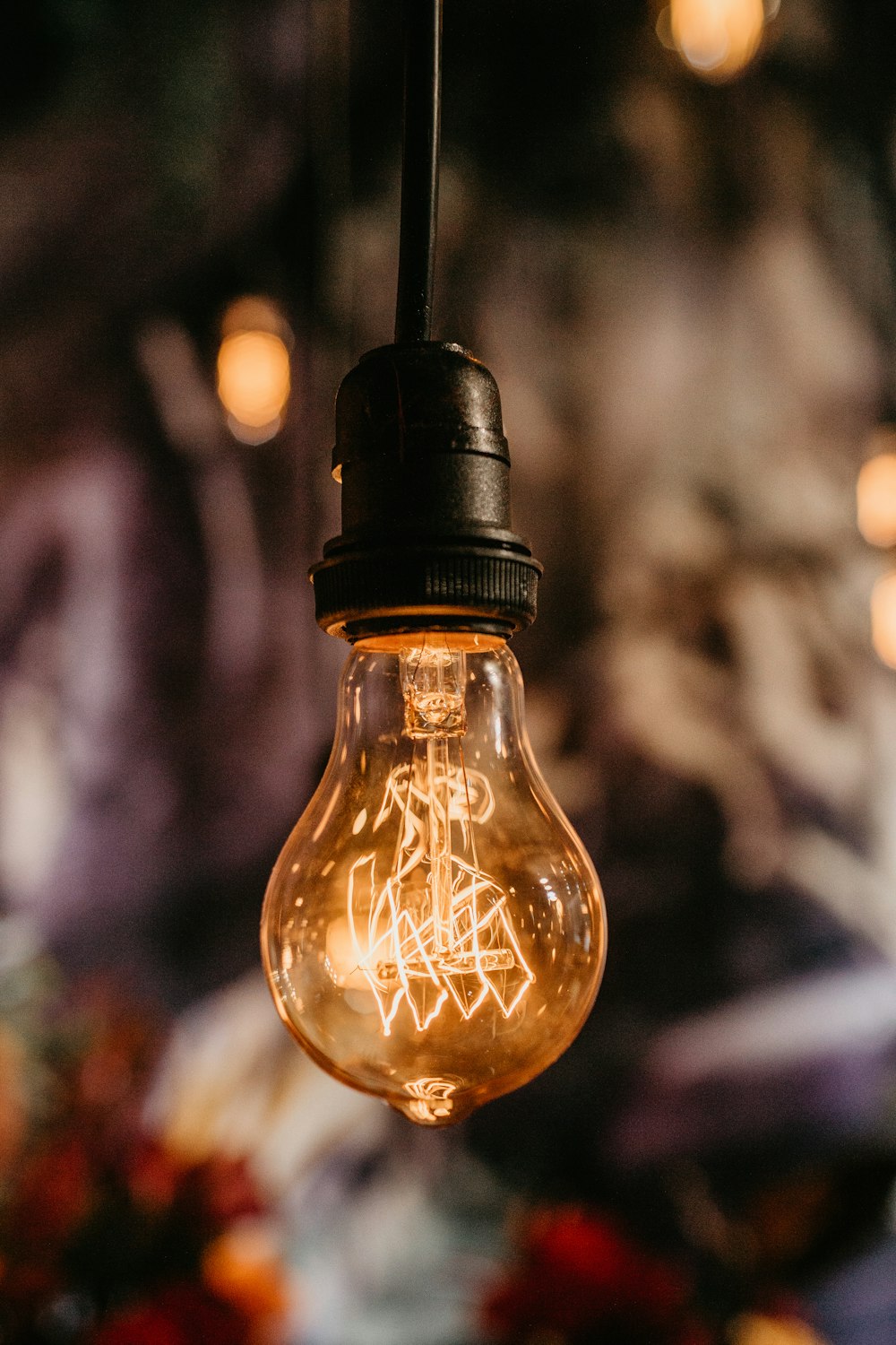 hanging black and clear light bulb turned on