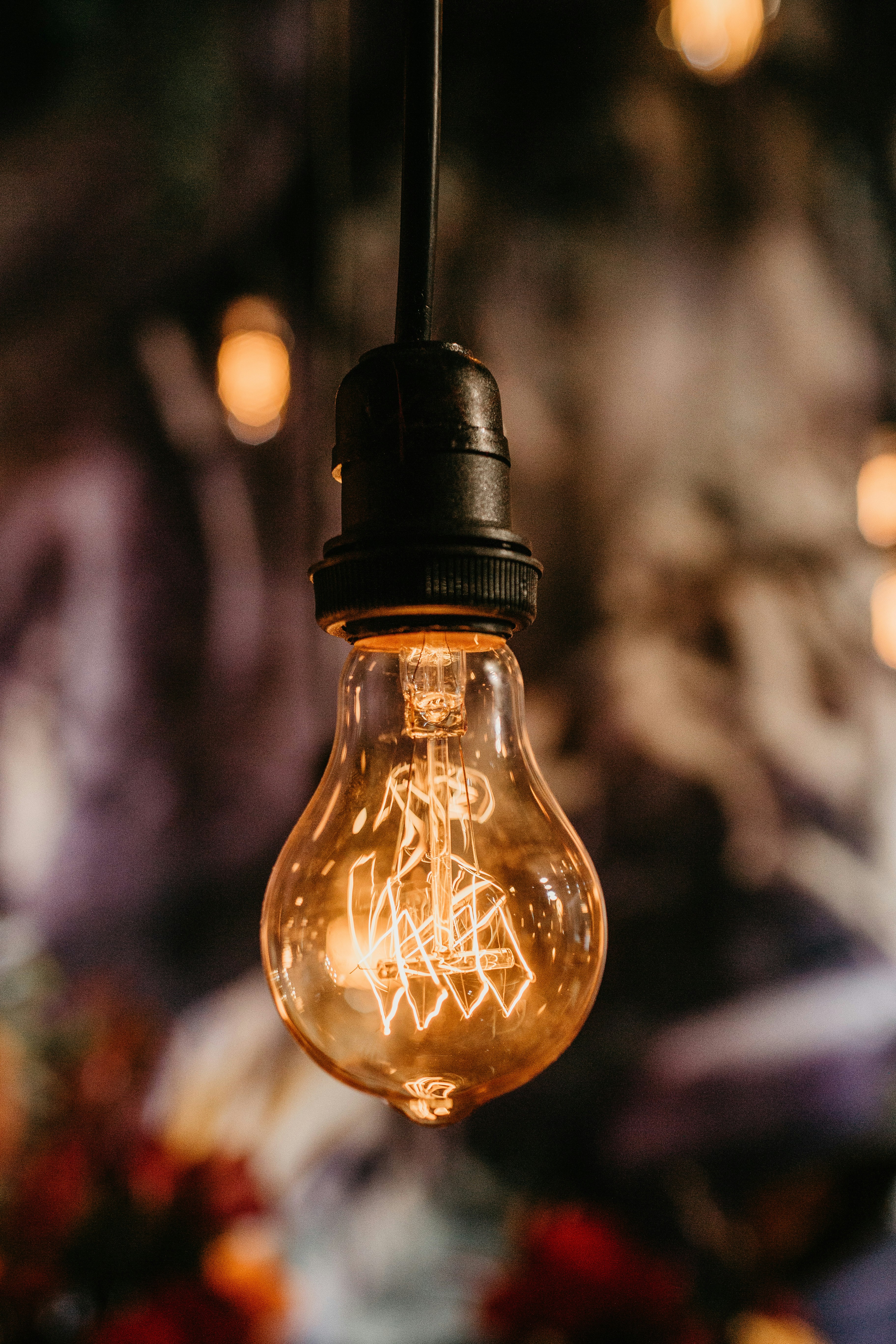 hanging black and clear light bulb turned on